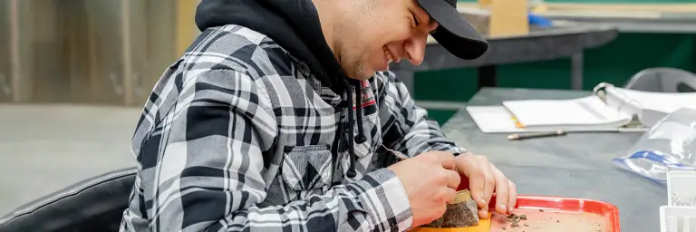 student works on edmontosaurus fossil
