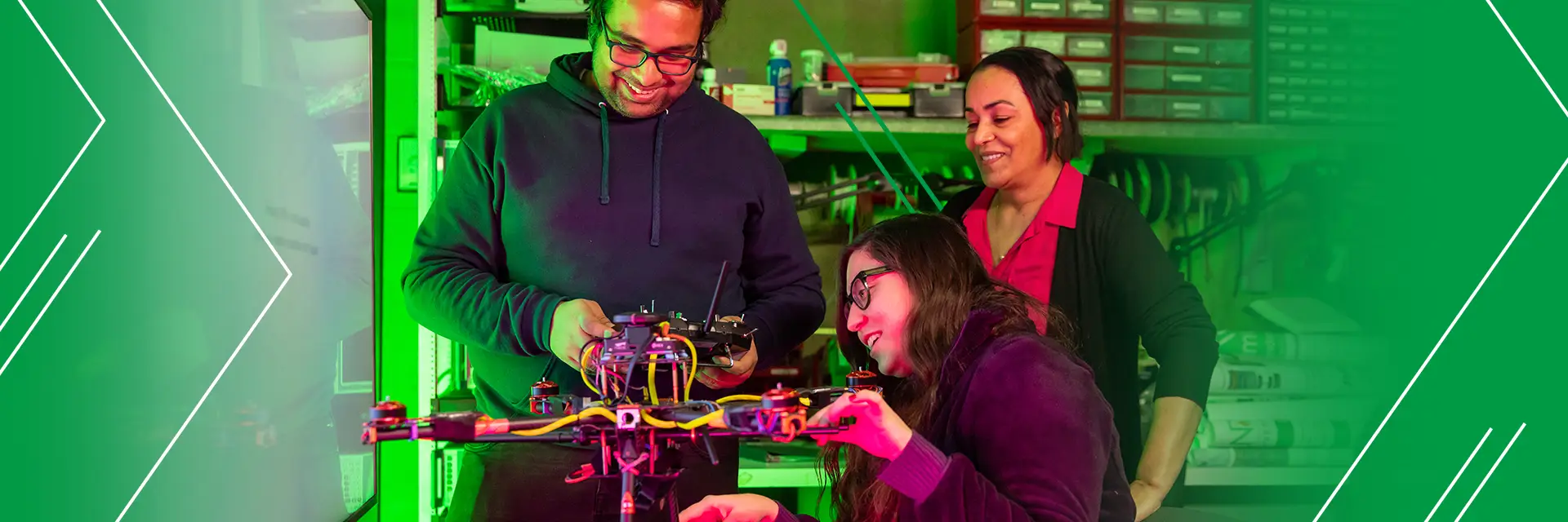 three students work with the mechanics of a drone