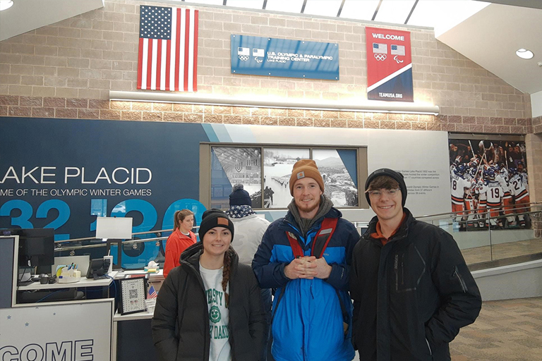 three students pose in the airport in Lake Placid, N.Y.