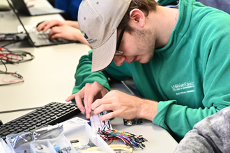 a student works on a circuit in an electrical engineering lab
