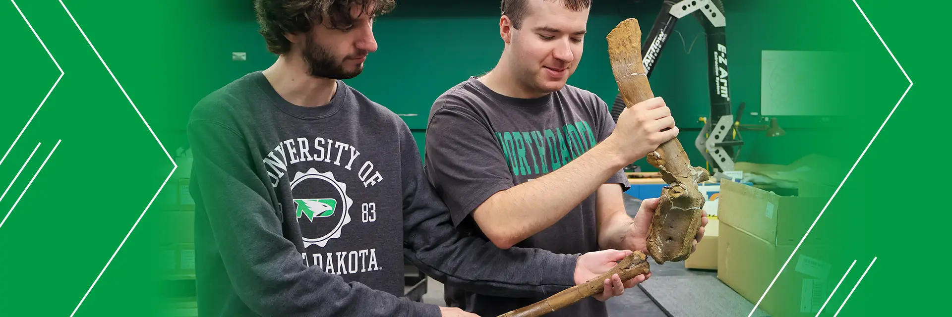 two students hold and examine a fossil