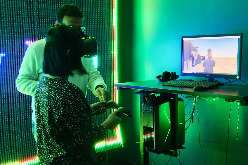 a student works with goggles and hand controls in a virtual reality lab