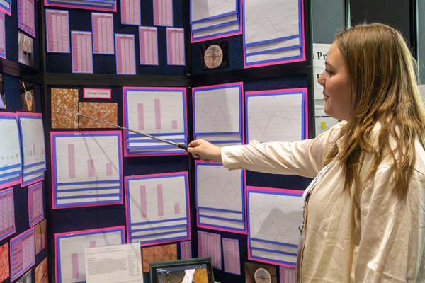 girl points to science fair display