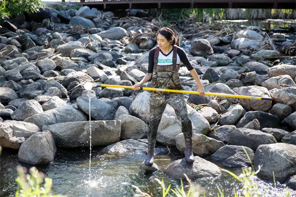 und student researching water in stream